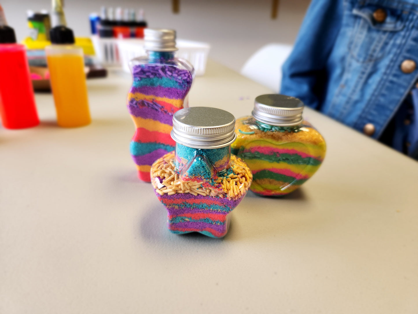 Colorful bottles with bath powders and bath sprinkles on a table