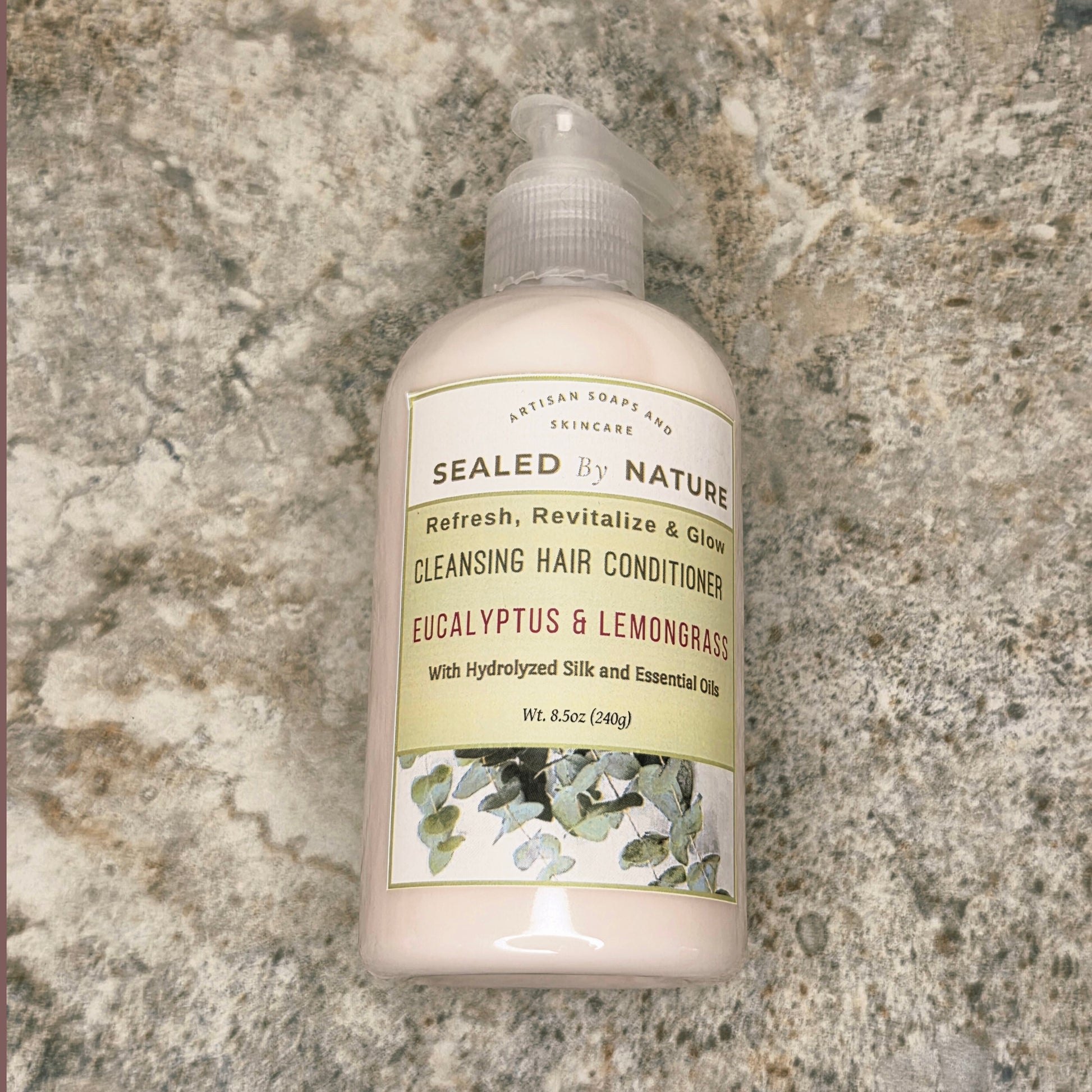 Bottle of cleansing hair conditioner labeled 'Sealed by Nature' on a granite countertop.