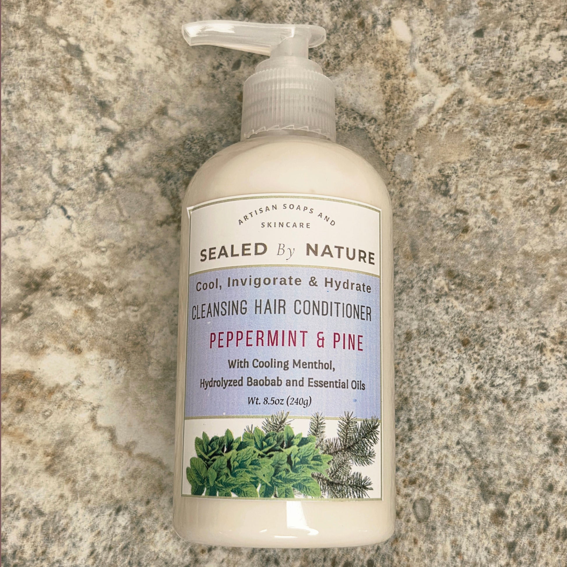 Bottle of Sealed by Nature cleansing hair conditioner on a stone surface