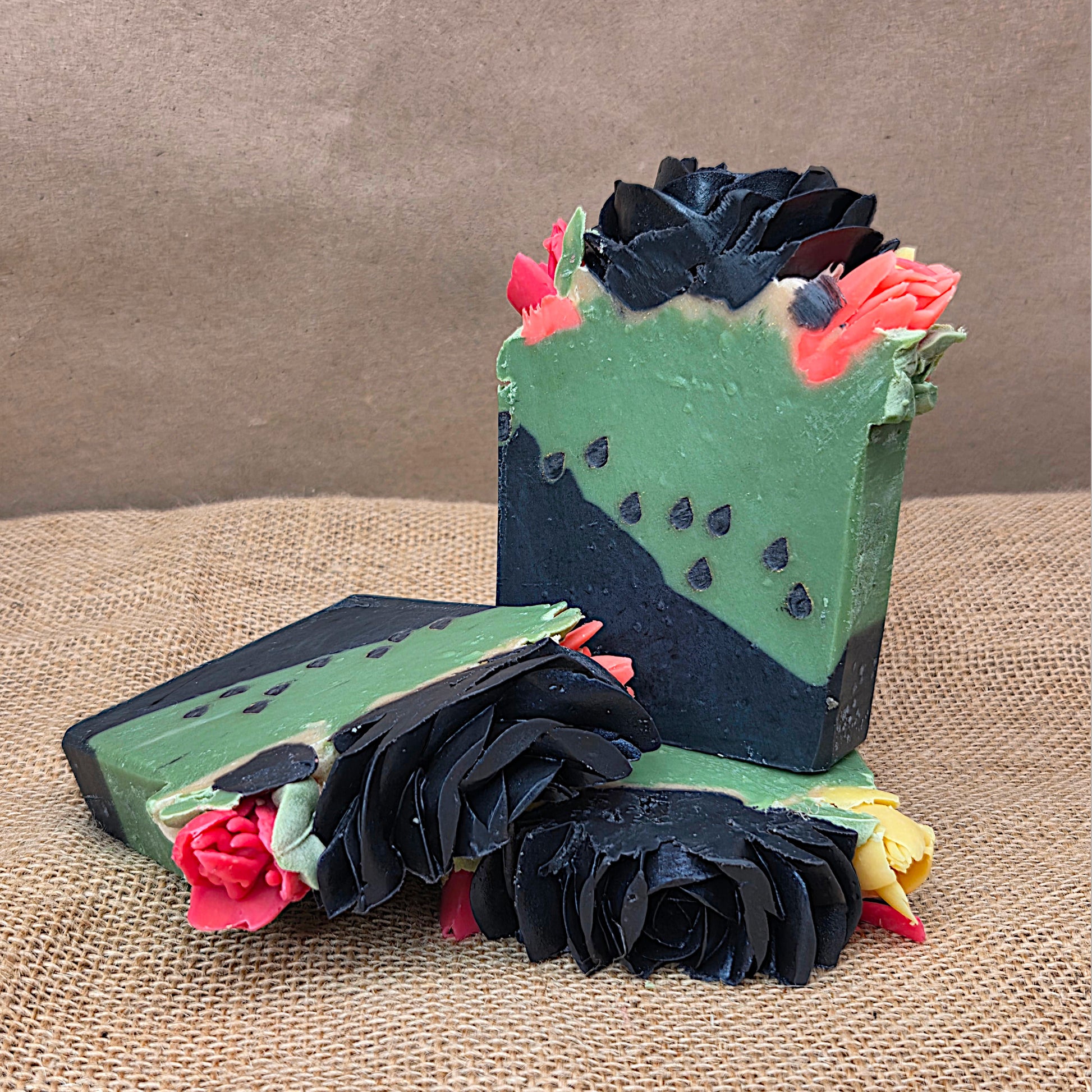 Decorative soap with black and green floral design on a textured surface