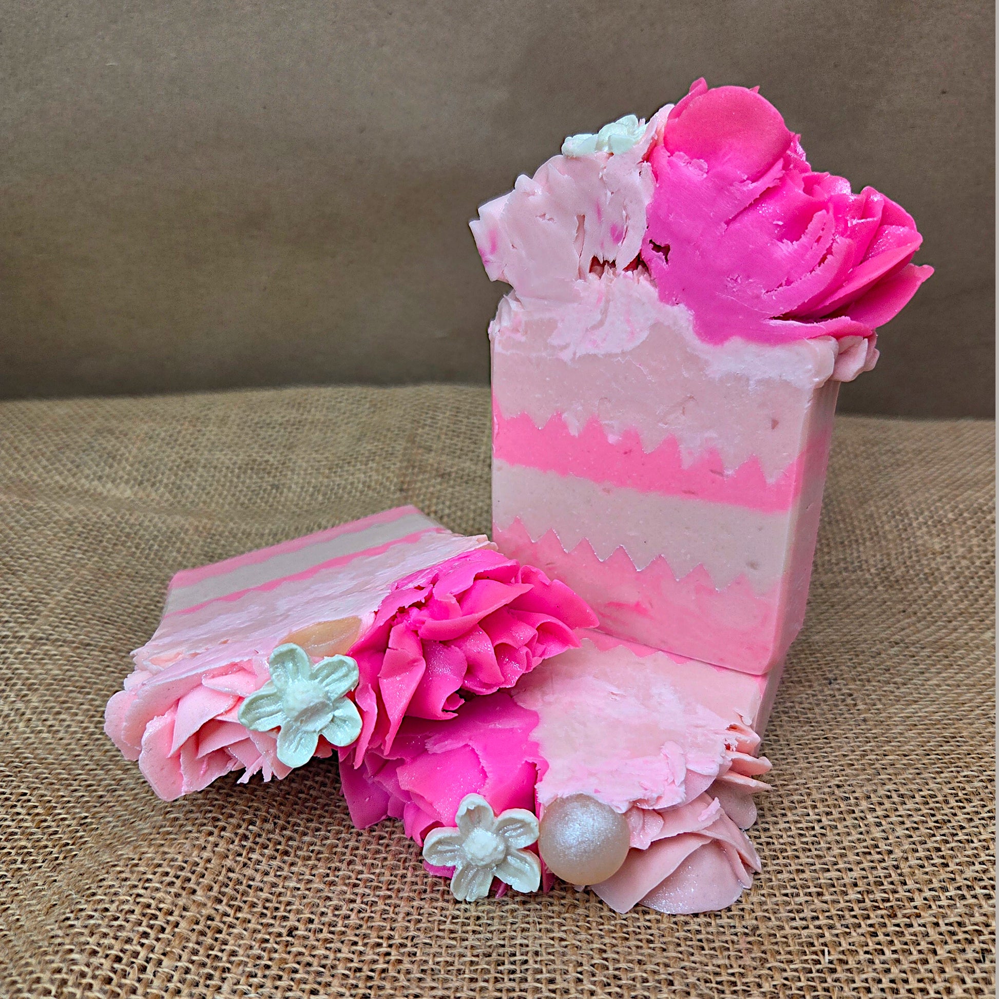 Decorative pink soap with floral elements on a textured surface