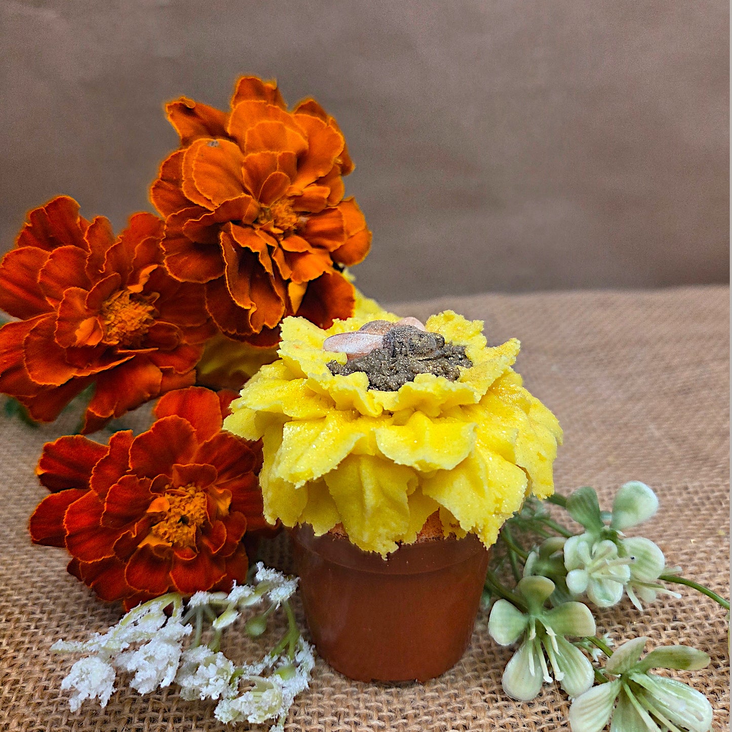 orange flowers and sunflower in brown pot