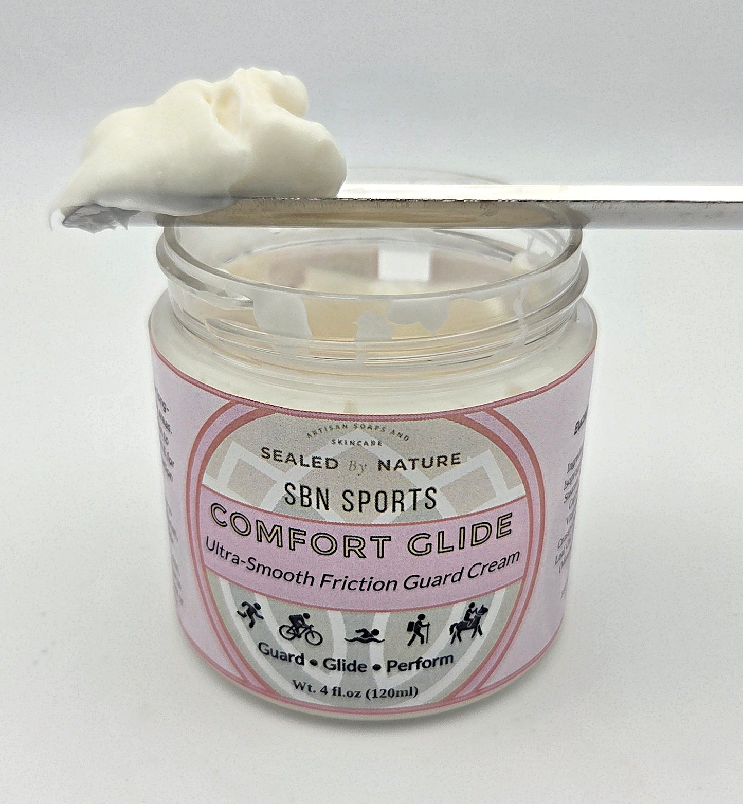 Jar of SBN Sports Comfort Glide cream with a spoonful of cream on a white background