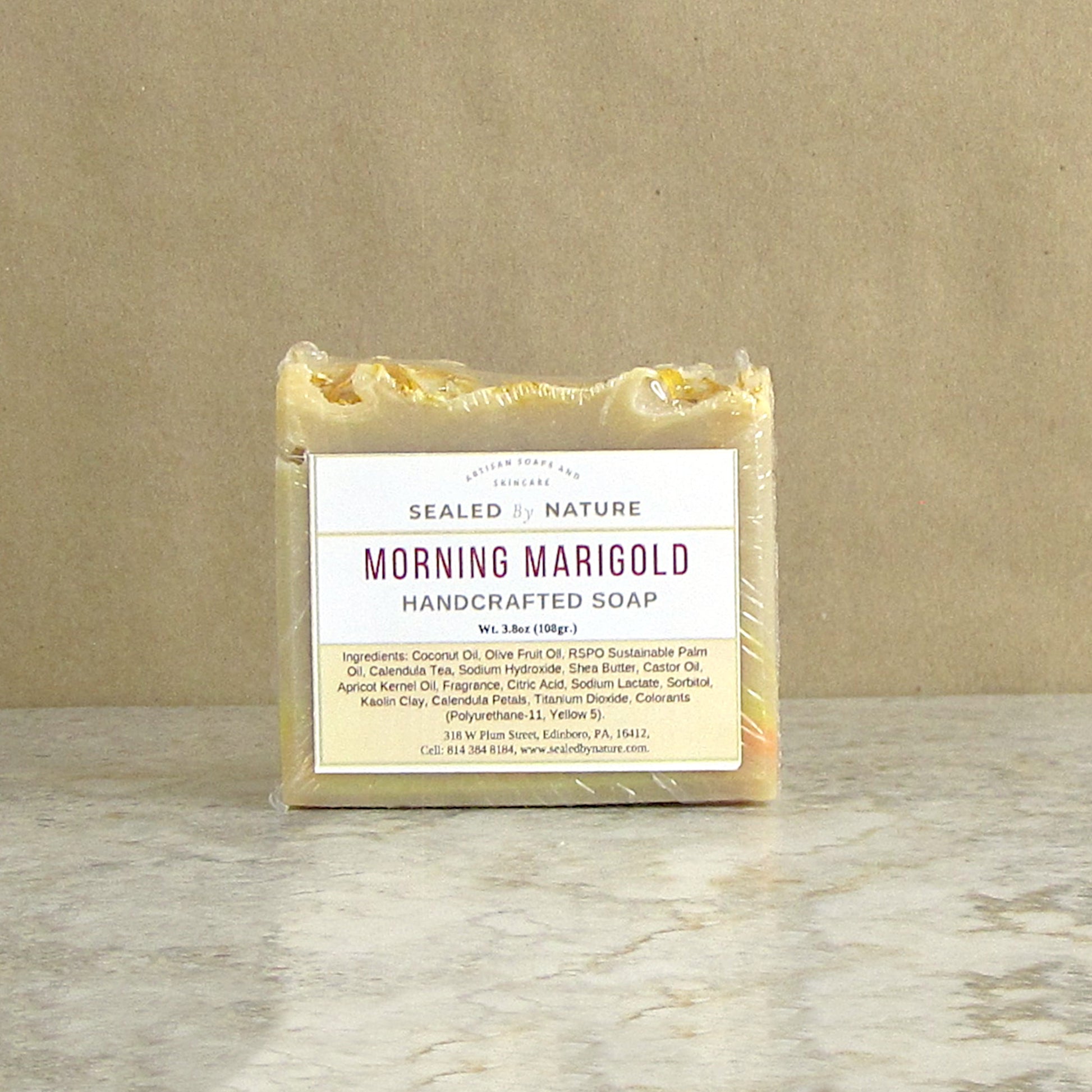 Handcrafted soap bar with a label on a marble surface and brown background