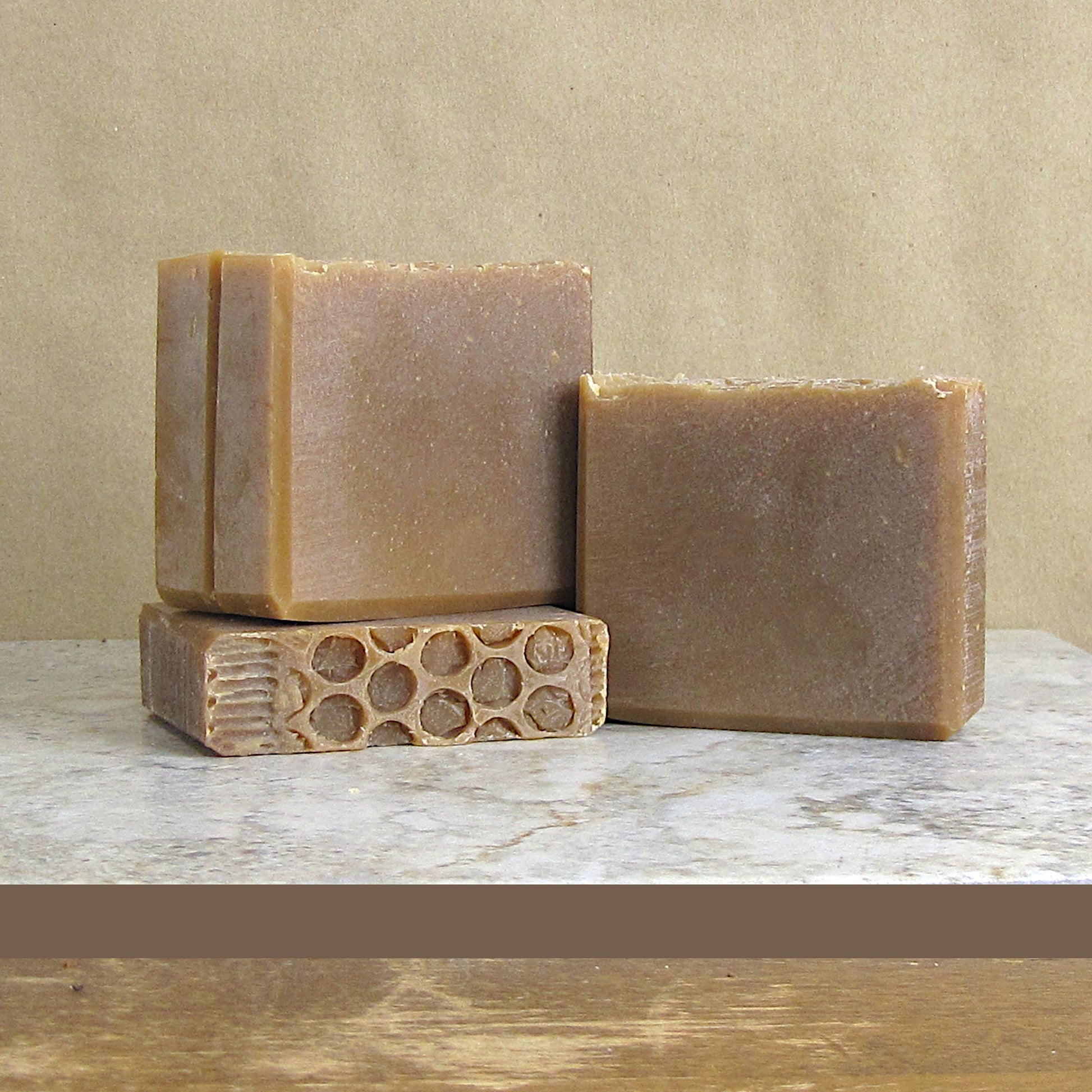 Goat Milk and Honey handcrafted soap bars with a honeycomb design on a wooden surface.