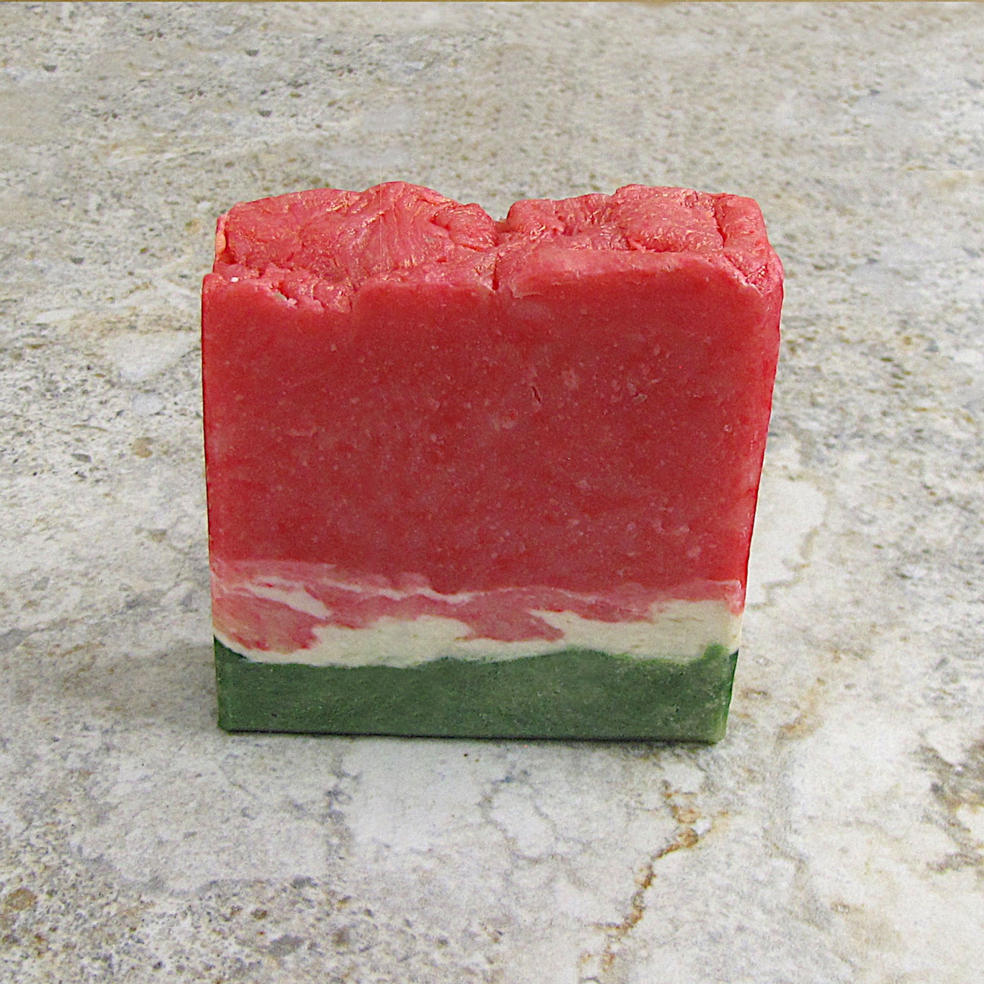 A soap bar that looks like a watermelon slice on the table.