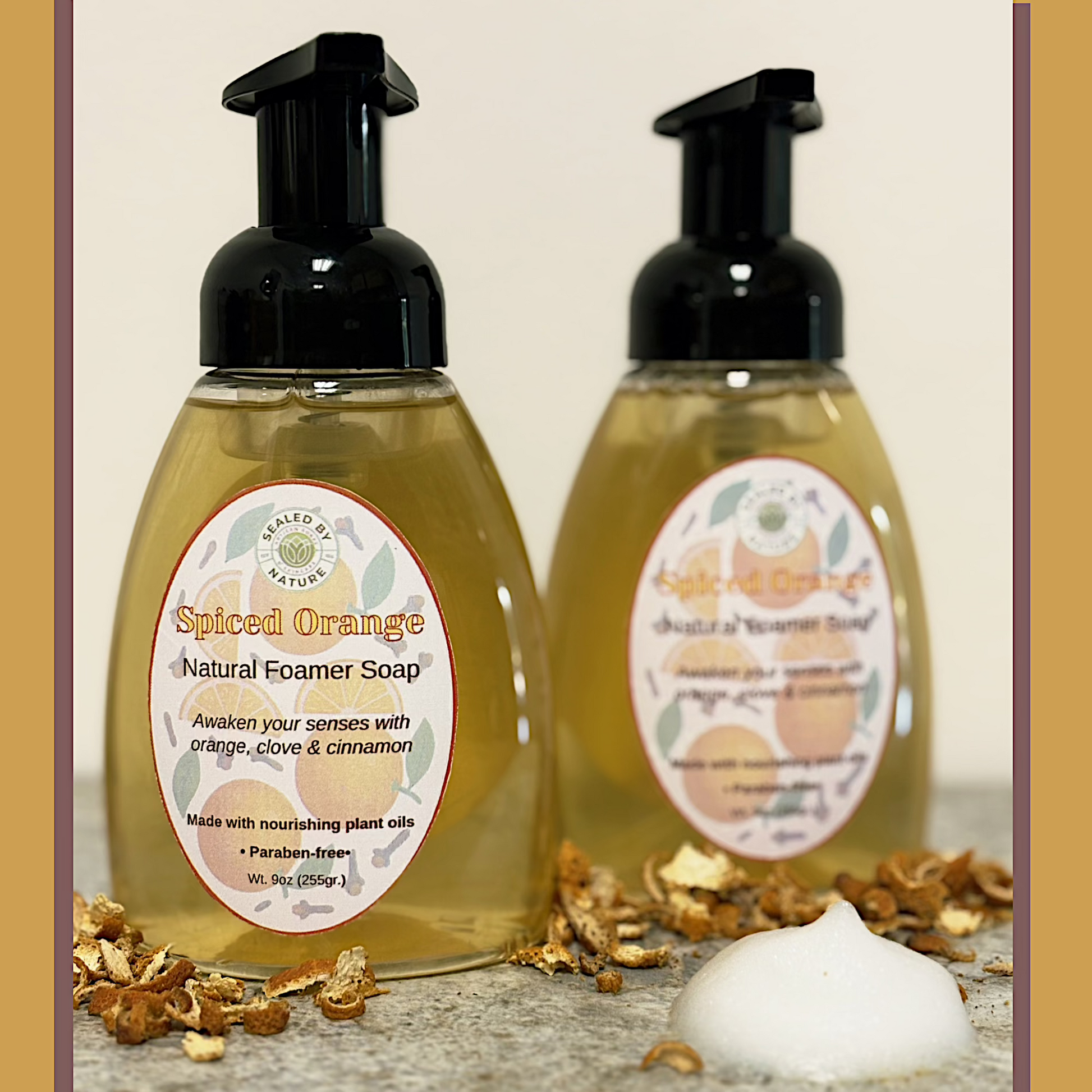 Two bottles of Spiced Orange Natural Foamer Soap with labels on a neutral background.