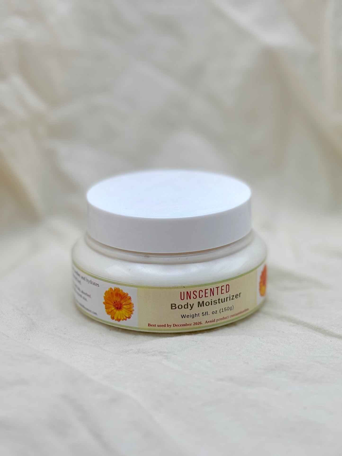 Unscented body moisturizer jar on a beige fabric background