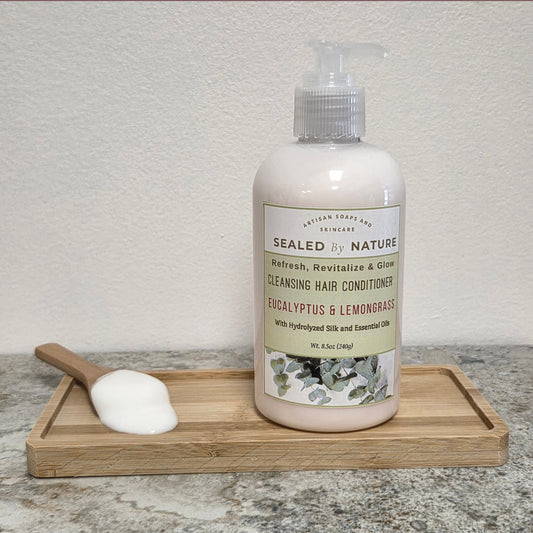 Bottle of cleansing hair conditioner with a wooden scoop on a tray against a neutral background