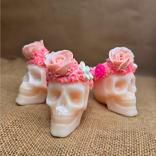 three pink skulls on brown mesh with brown background