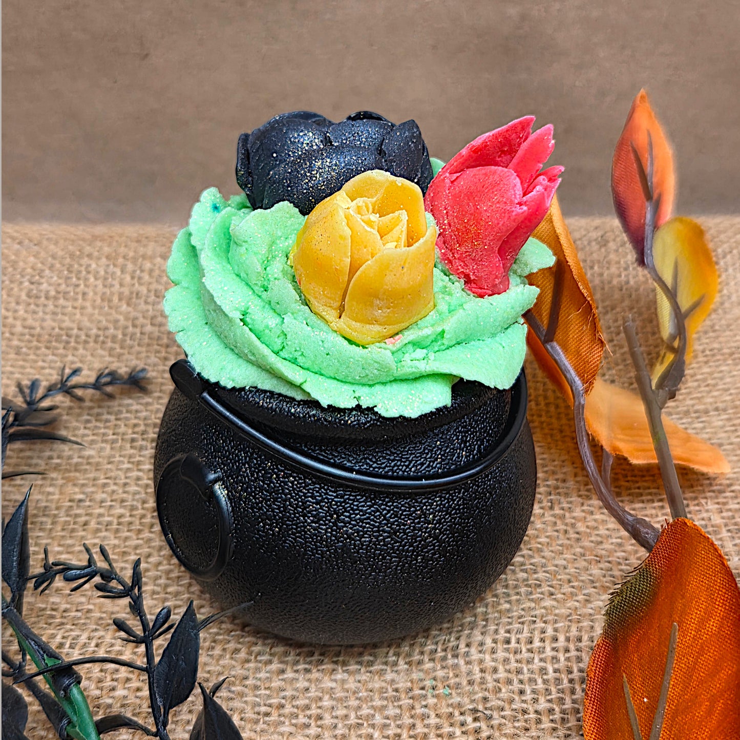 one black cauldron with fall leaves around