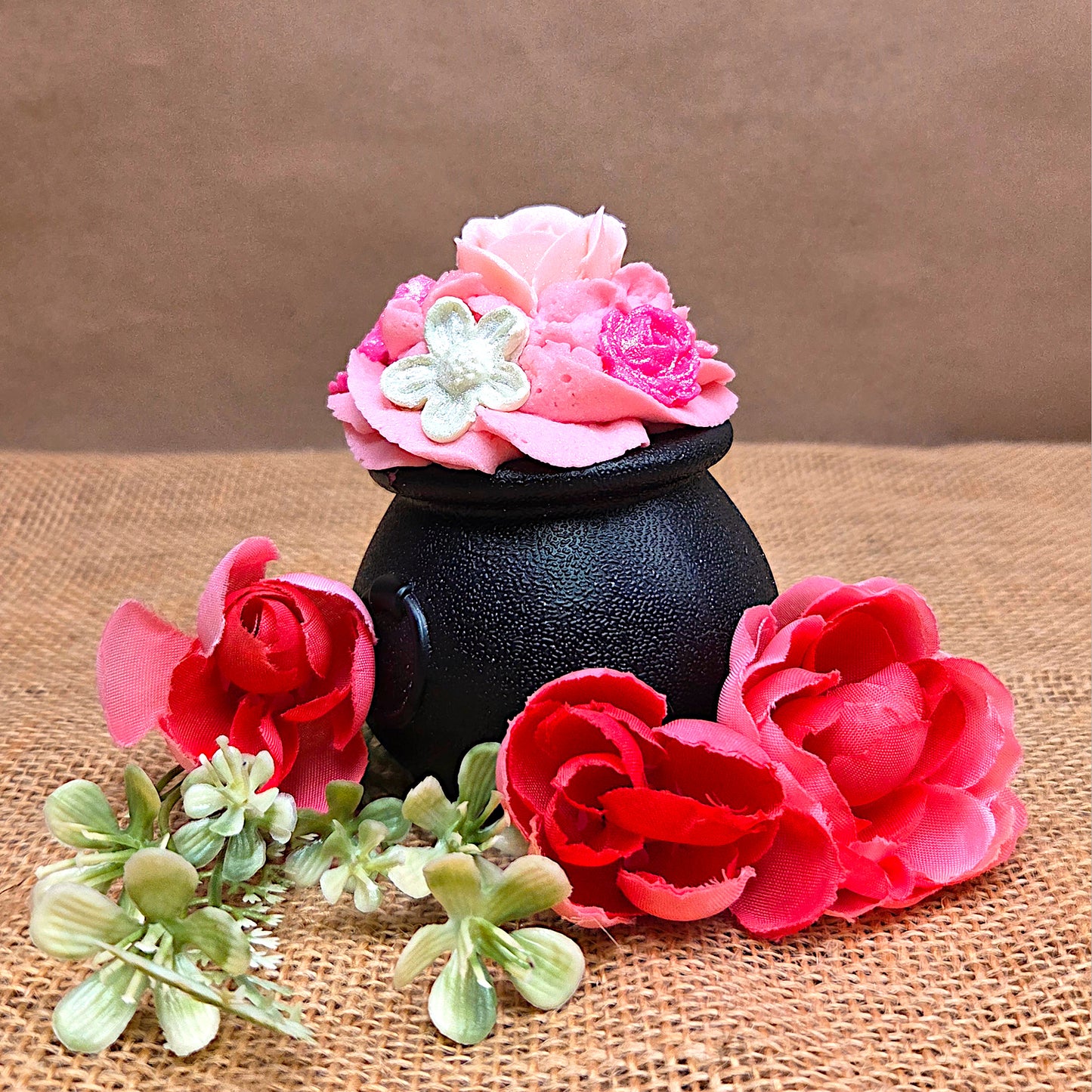 black cauldron with pink flowers around