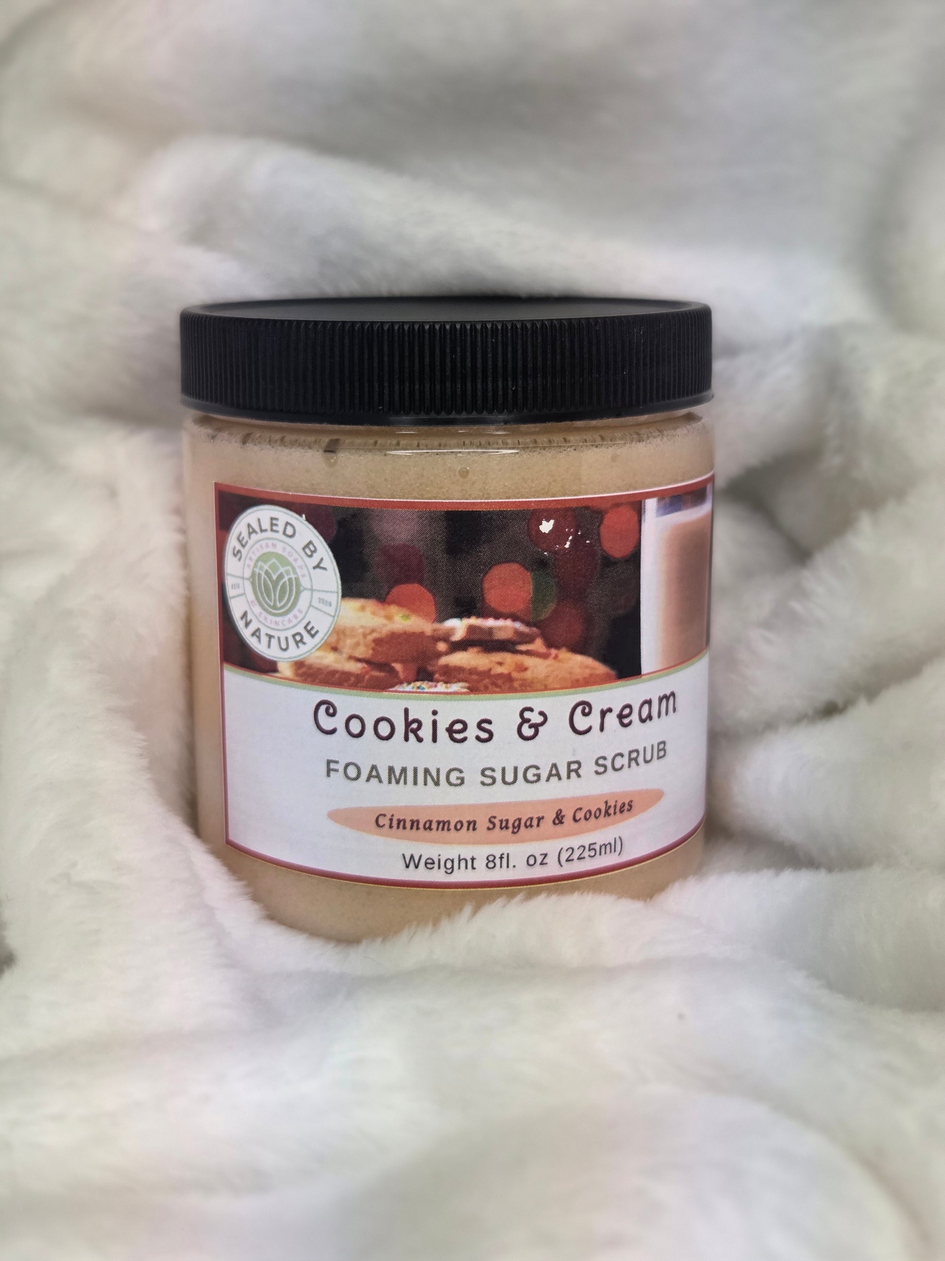 Jar of 'Cookies & Cream' foaming sugar scrub on a textured white surface
