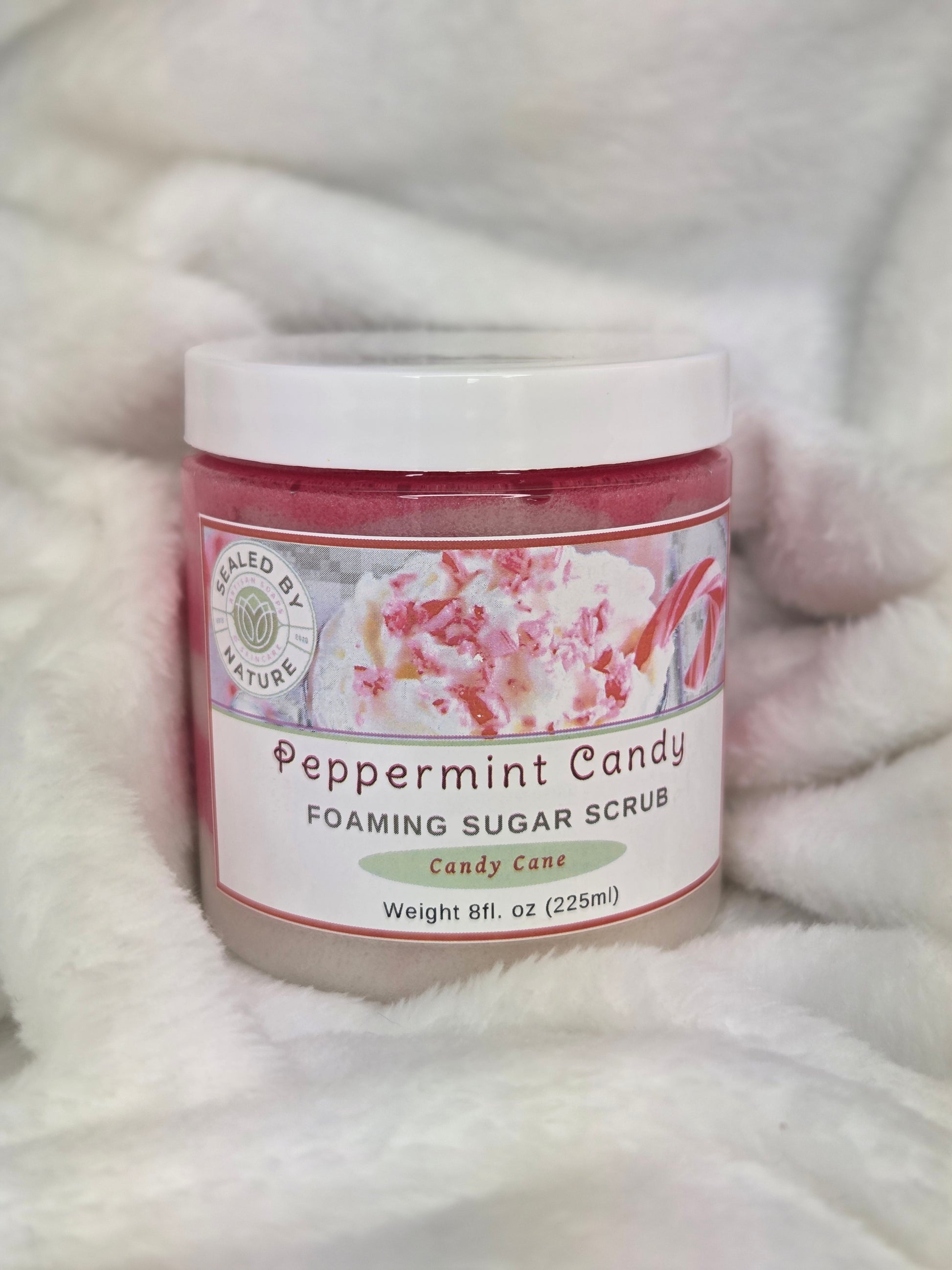 Peppermint candy foaming sugar scrub container on a soft fabric background