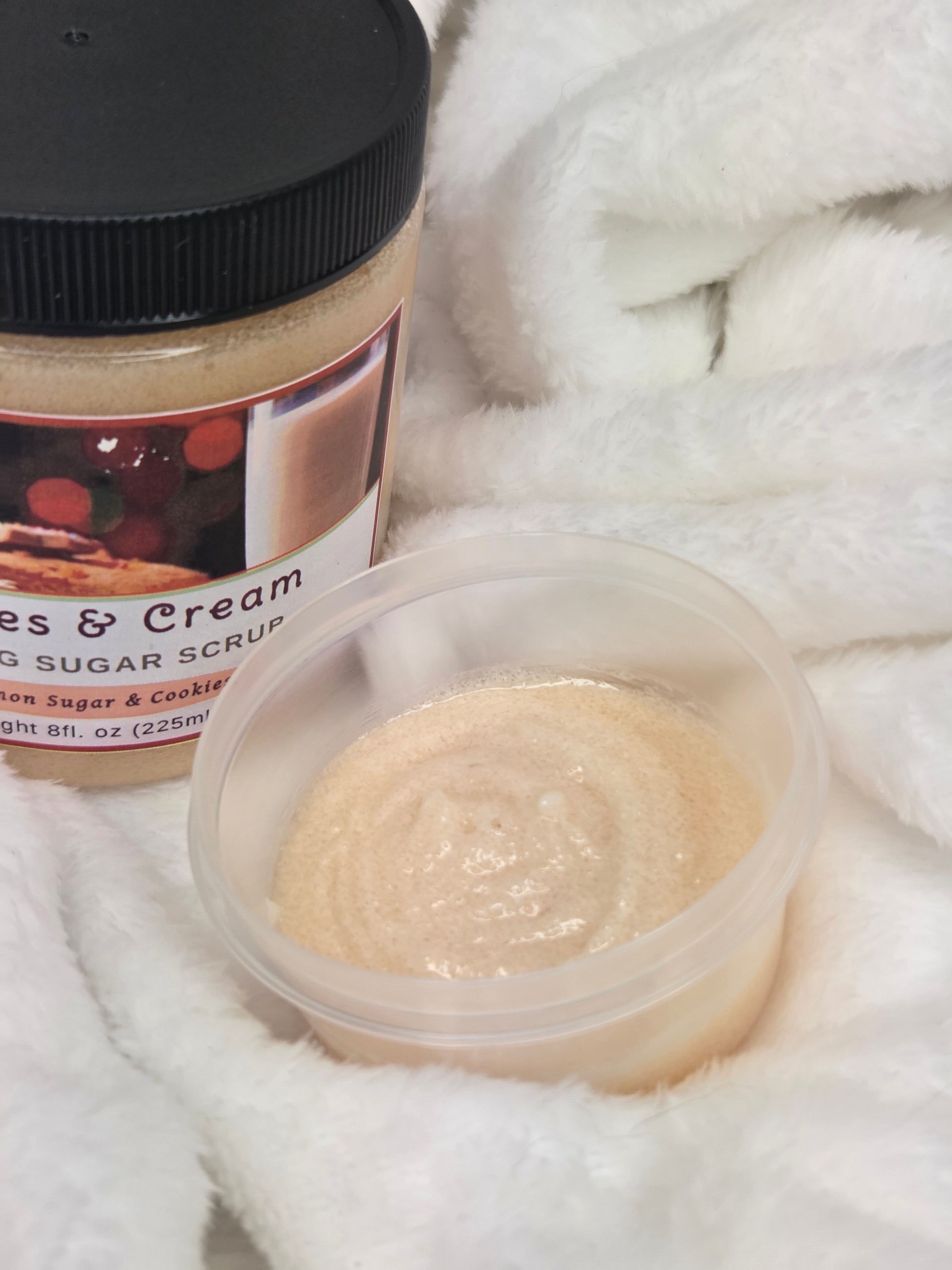 Jar of body scrub with a sample scrub on a white towel
