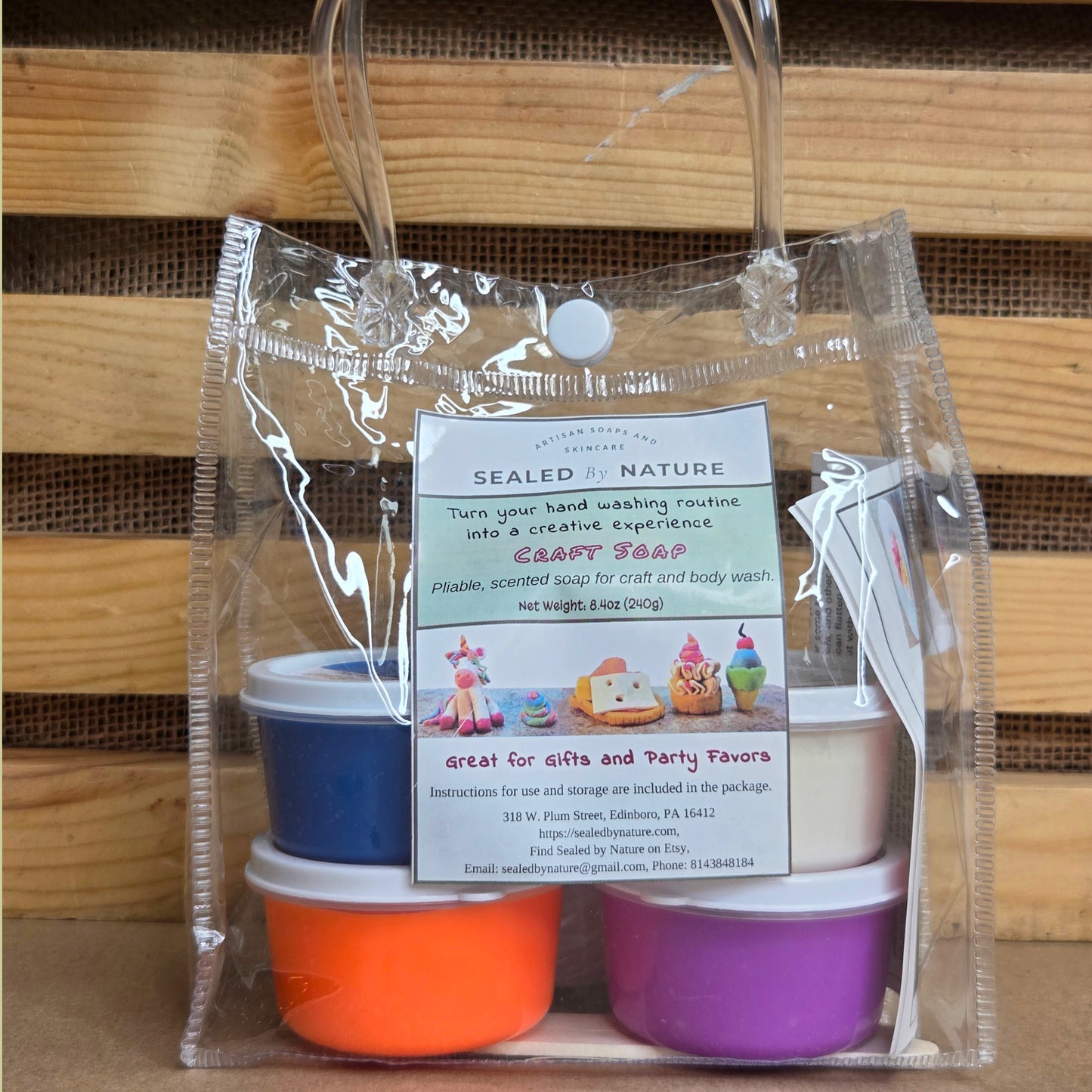 Set of four small containers in blue, orange, and purple with a clear bag on a wooden background
