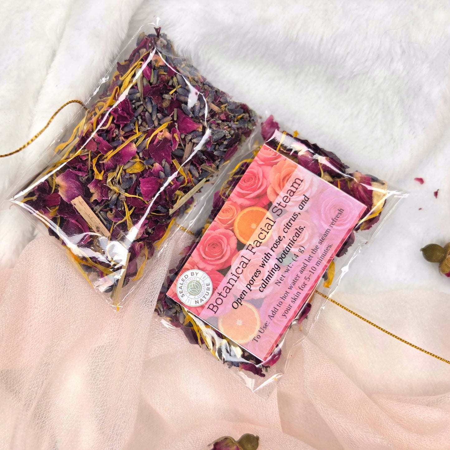 Packaged botanical facial steam with dried flowers on a white fabric background