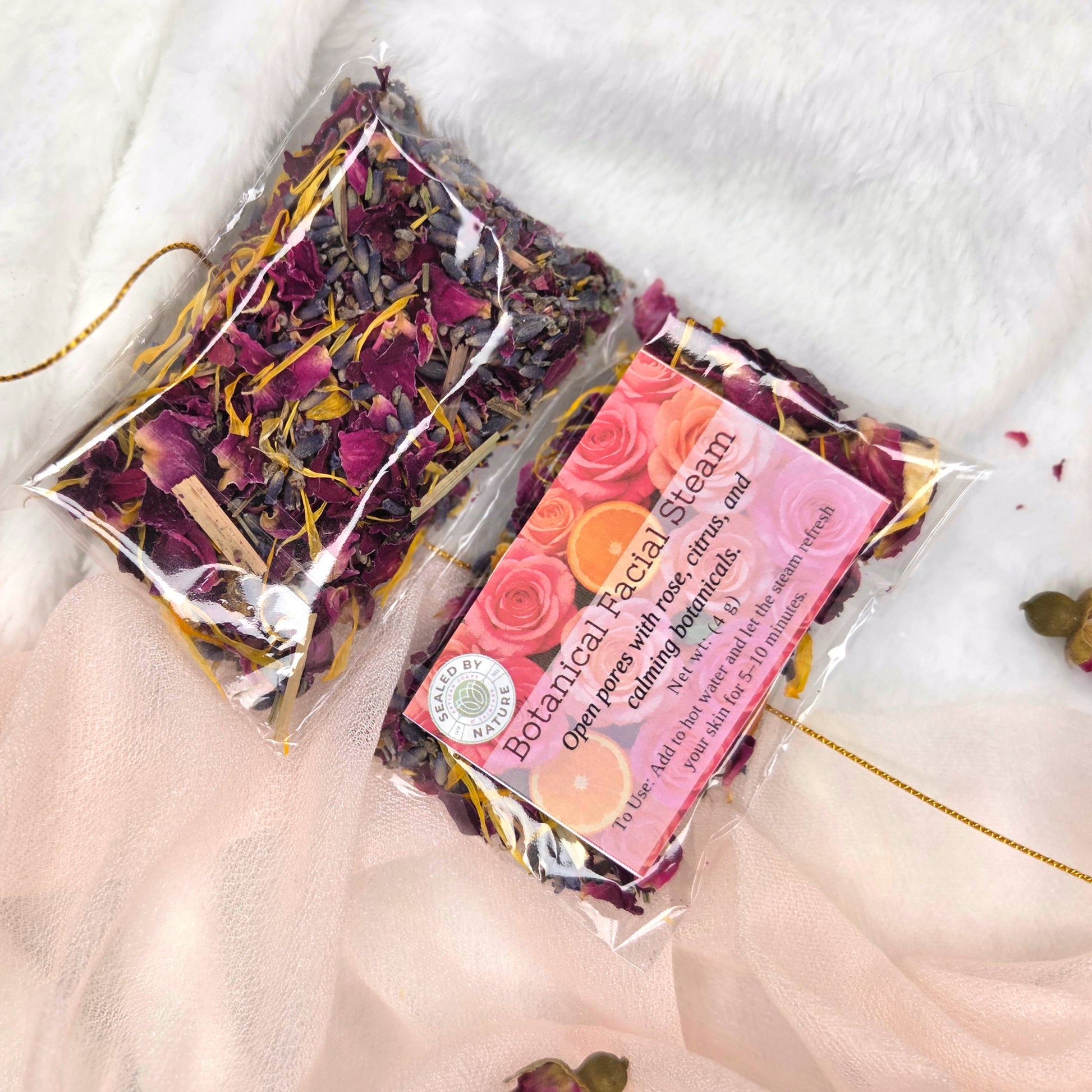 Packaged botanical facial steam with dried flowers on a white fabric background