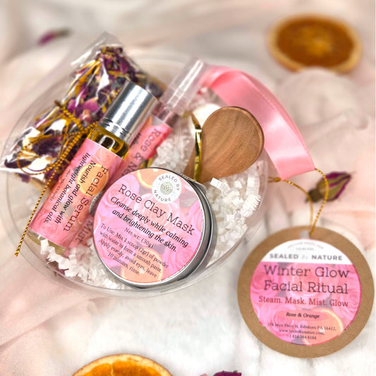 Skincare products with pink packaging on a white surface, including a facial mask and mist bottle.