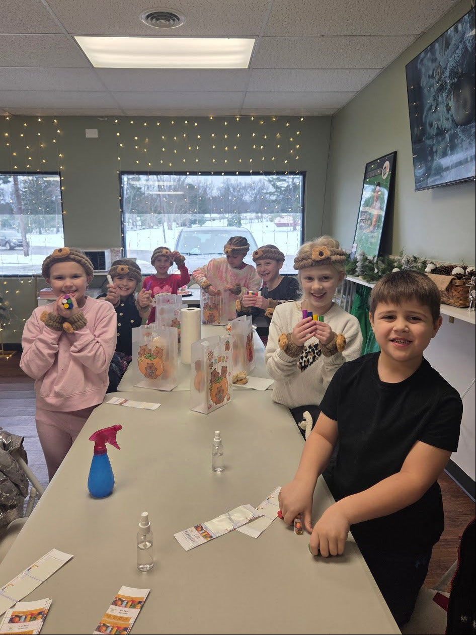 Children at a table with craft materials in a room with a snowy view outside