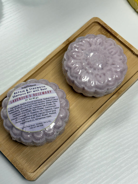 Two purple shampoo bars on a wooden tray scented Lavender & Rosemary.