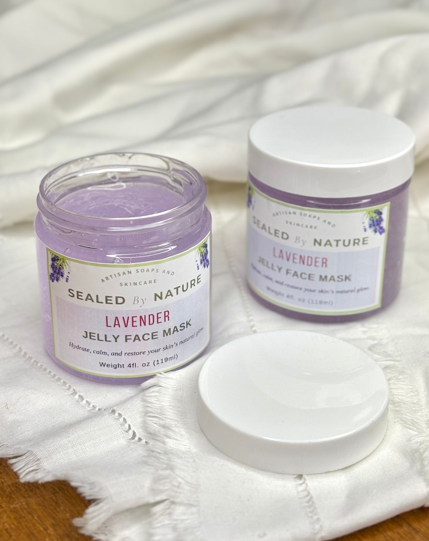 Two jars of Sealed by Nature Lavender Jelly Face Mask on a white fabric background
