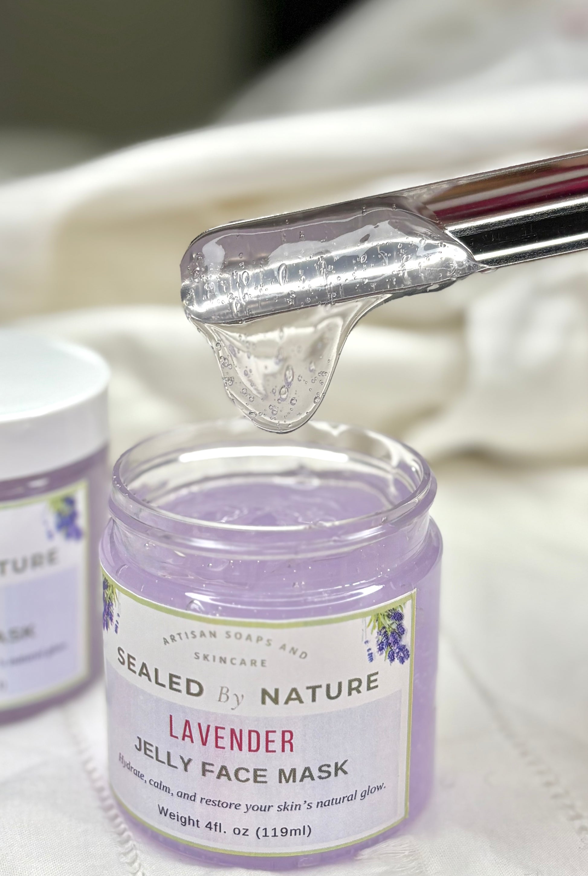 Lavender jelly face mask jar with a dropper on a white background