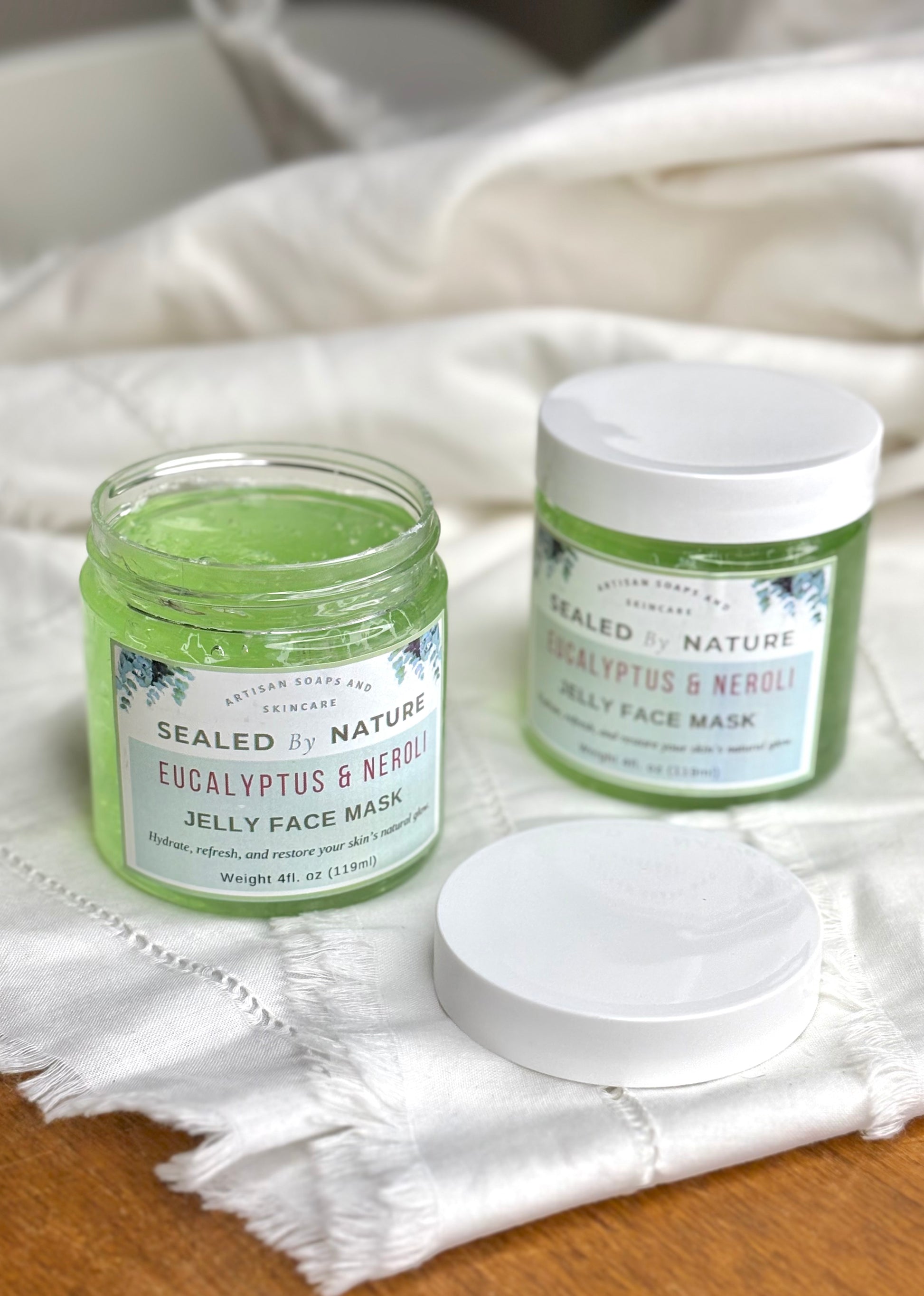 Two jars of Sealed by Nature Eucalyptus & Neroli Jelly Face Mask on a white cloth.