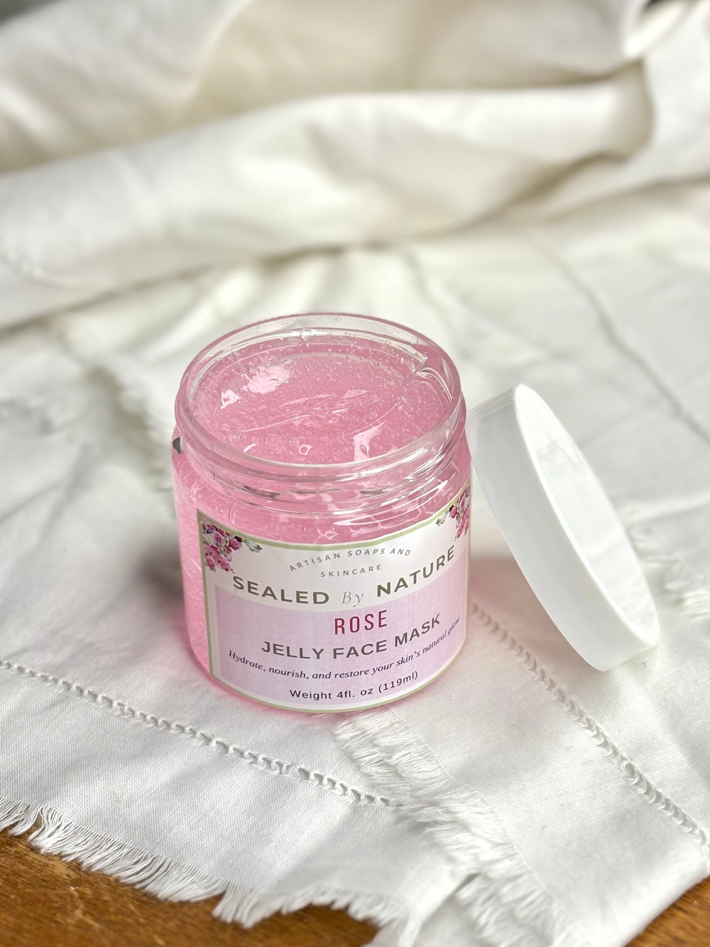Jar of Sealed by Nature Rose Jelly Face Mask on a white fabric background