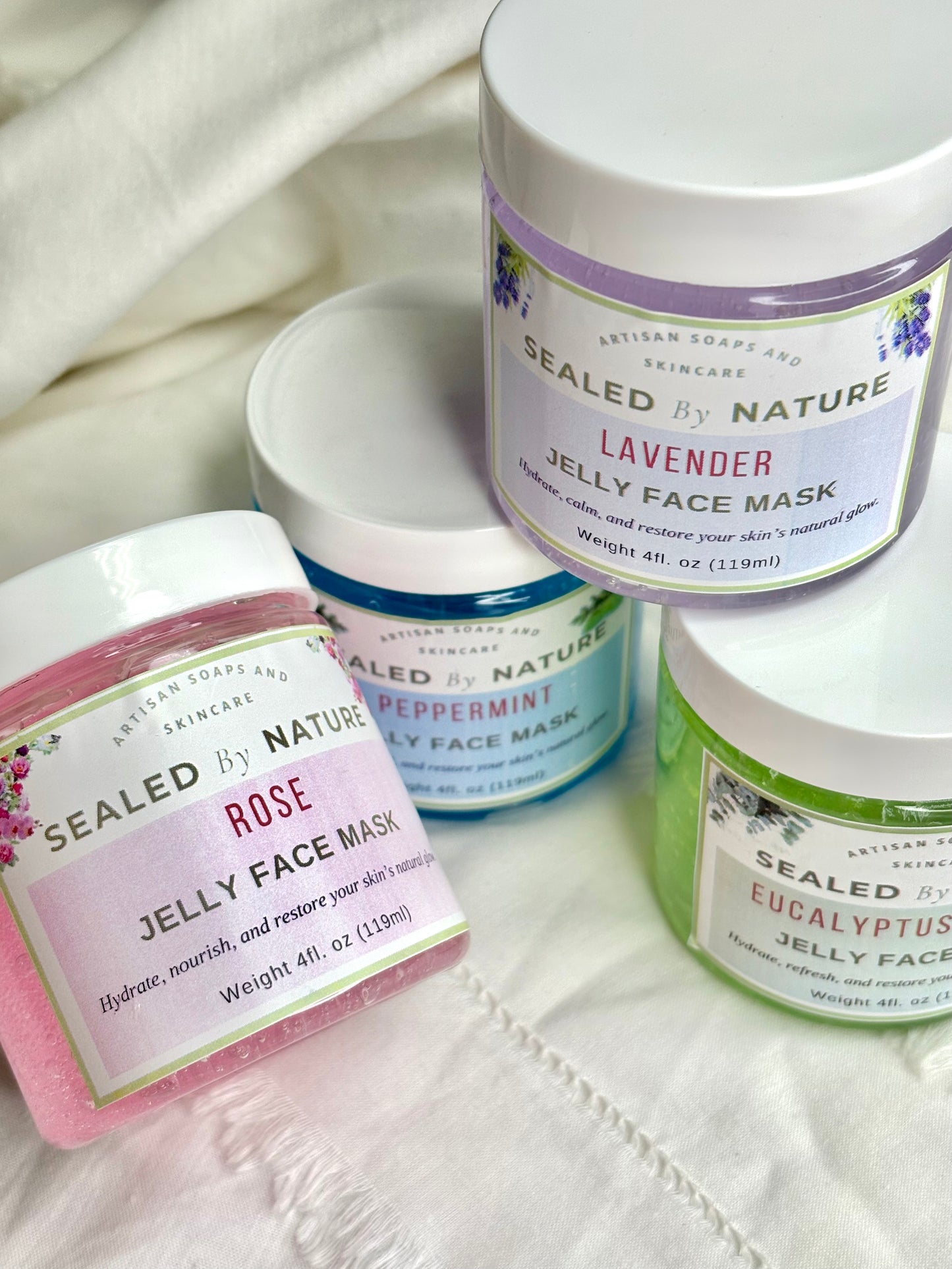 Jelly face masks with 'Sealed by Nature' labels on a white fabric background
