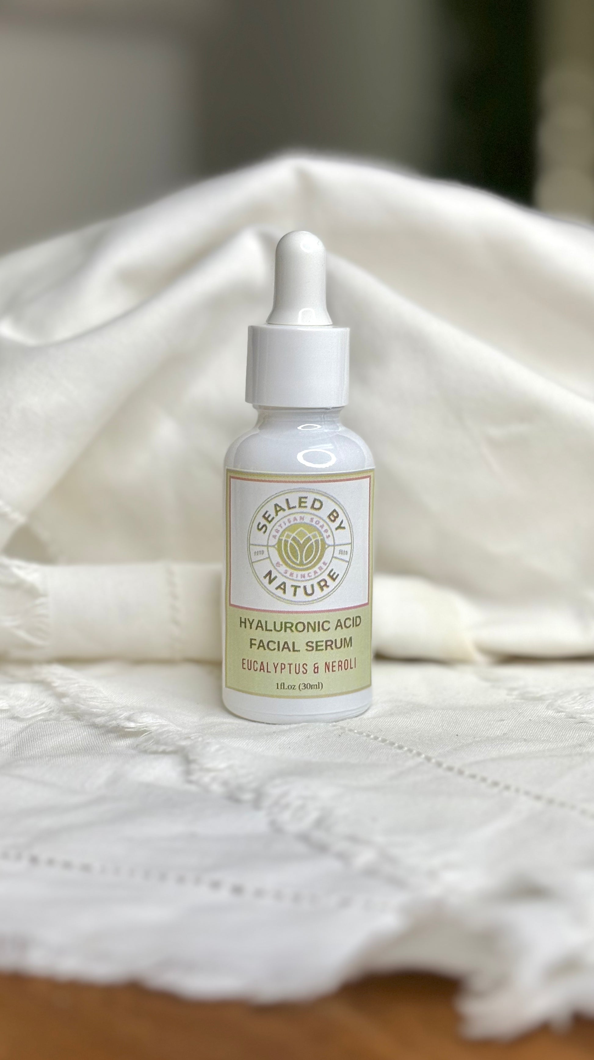 Eucalyptus facial serum bottle labeled 'Sealed by Nature' on a textured white surface