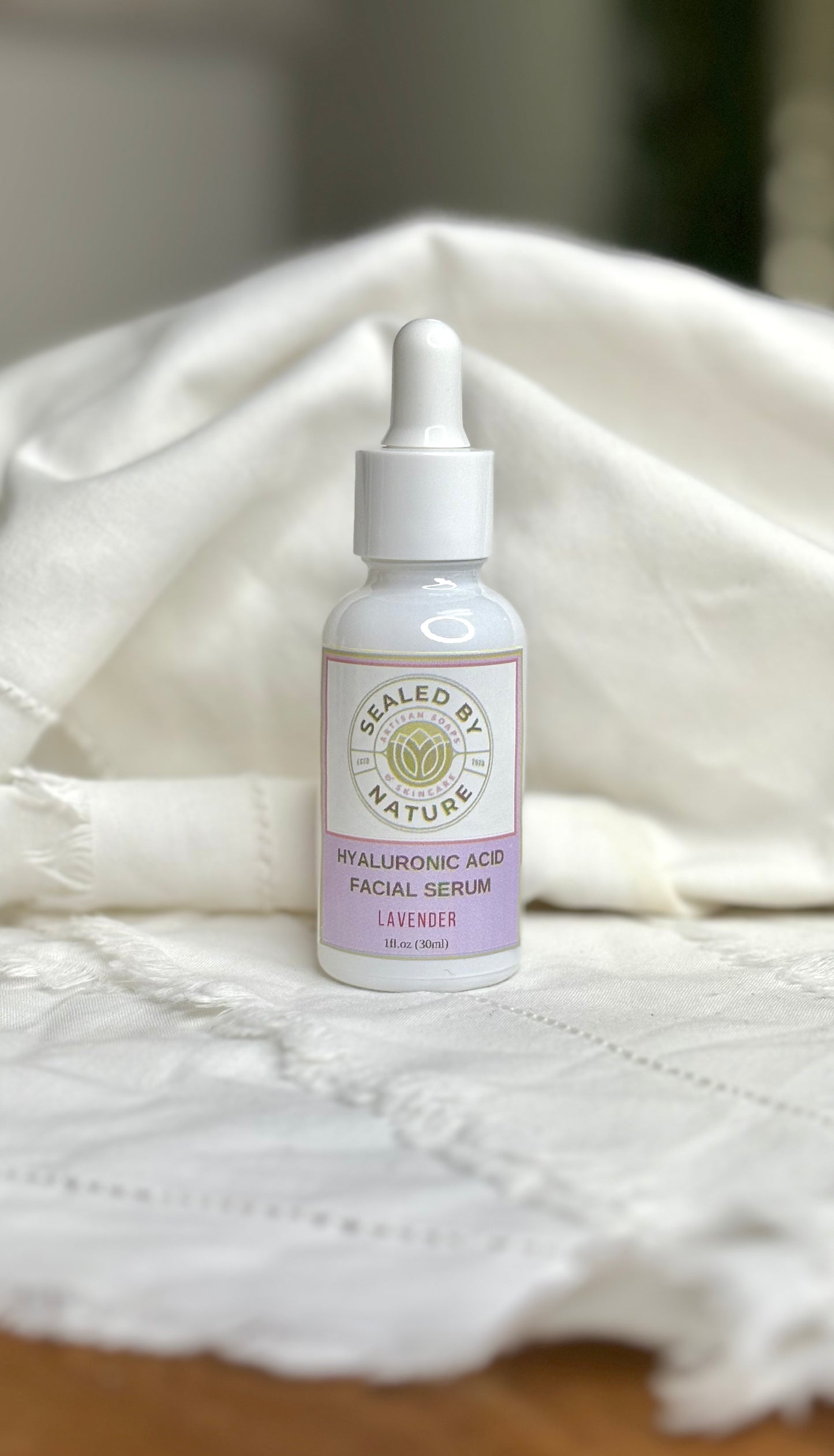  Lavender facial serum bottle with a dropper on a textured white surface