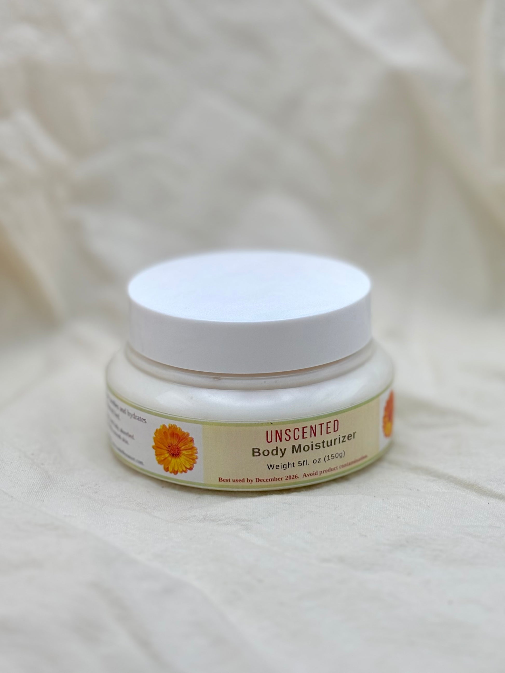 Unscented body moisturizer jar on a beige fabric background