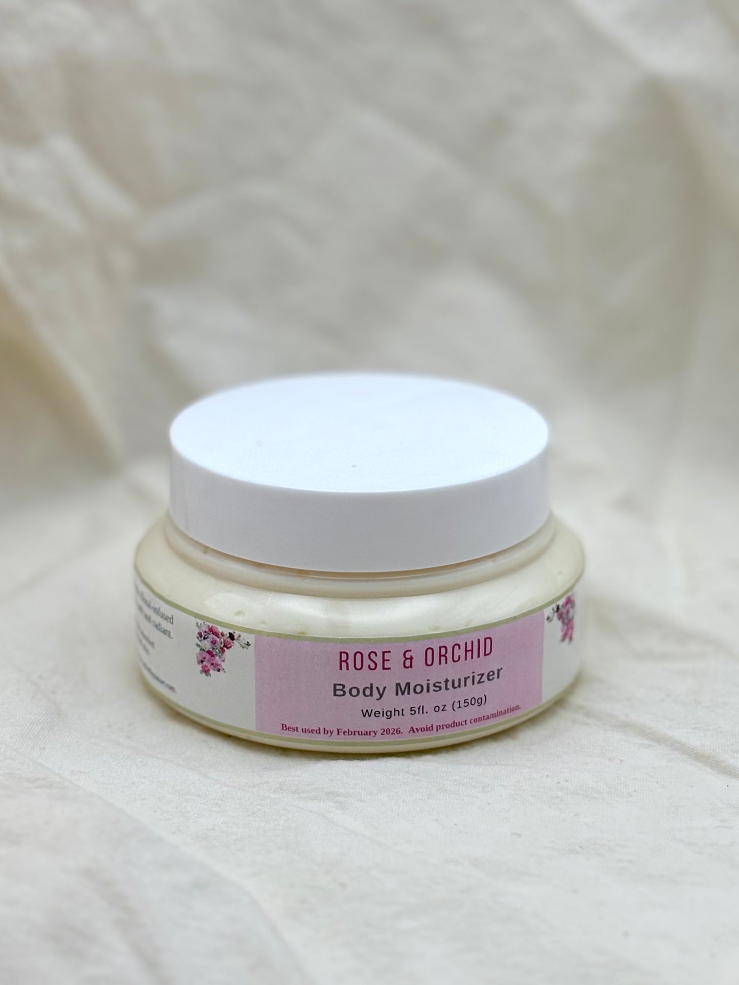 Jar of Rose & Orchid Body Moisturizer on a textured beige background