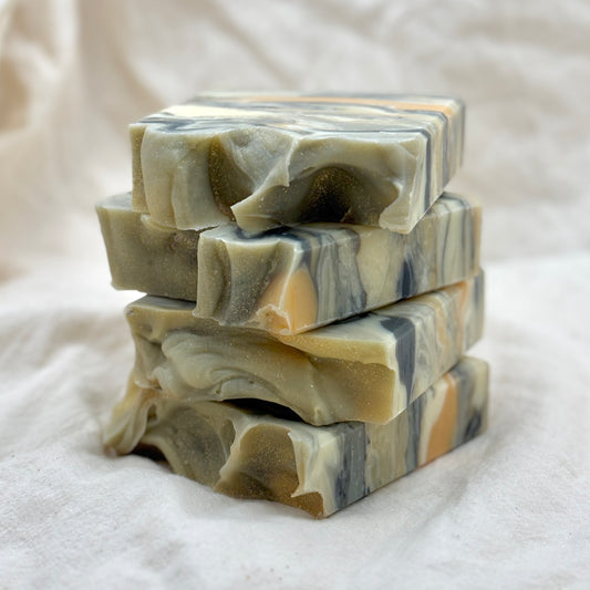 Stack of marbled soap bars on a white fabric background